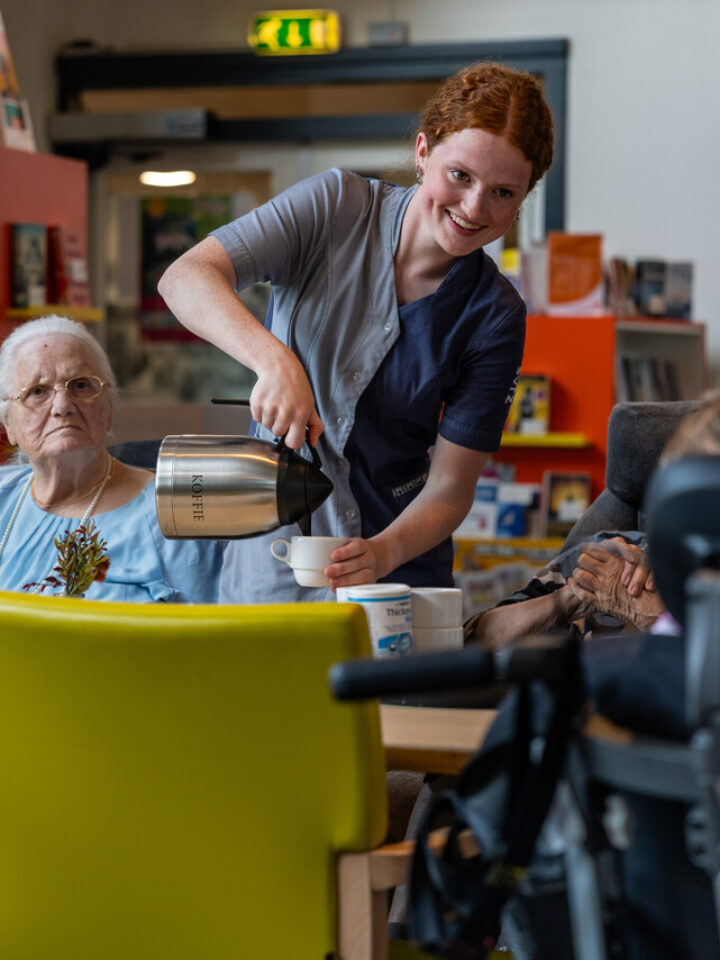 Een medewerker schenkt koffie in voor cliënten