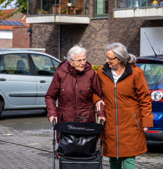 Een medewerker wandelt met een cliënt op straat