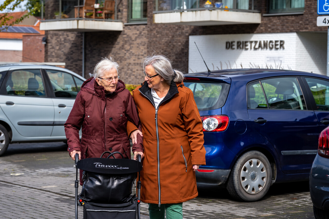 Een medewerker wandelt met een cliënt op straat