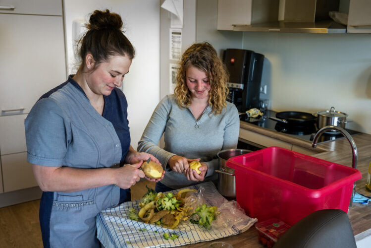 Twee medewerkers schillen aardappelen